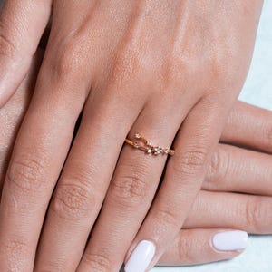 May include: A delicate gold ring with a constellation design featuring small sparkling diamonds.