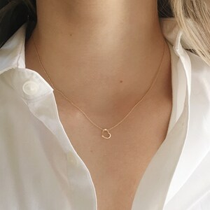 model wearing a 16 inch 14k gold filled necklace with a tiny heart charm.