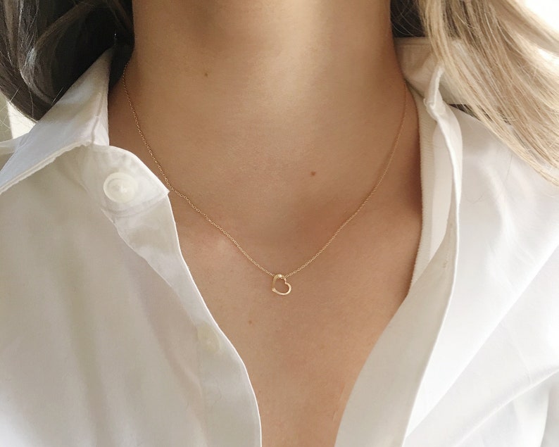 model wearing a 16 inch 14k gold filled necklace with a tiny heart charm.