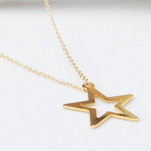 May include: A gold chain necklace with a large, open star pendant.
