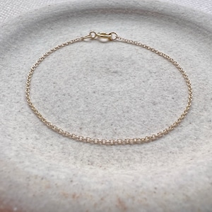 May include: A delicate gold chain bracelet with a simple clasp.