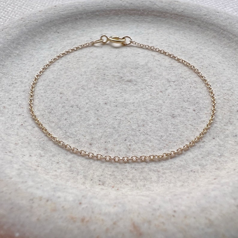 May include: A delicate gold chain bracelet with a simple clasp.