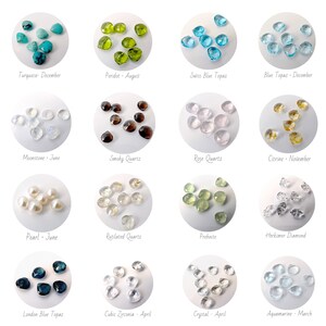 May include: A collection of 12 different gemstone heart shapes, each with a different color and name. The gemstones are arranged in a grid pattern on a white background. The names of the gemstones and their corresponding months are listed below each heart shape.
