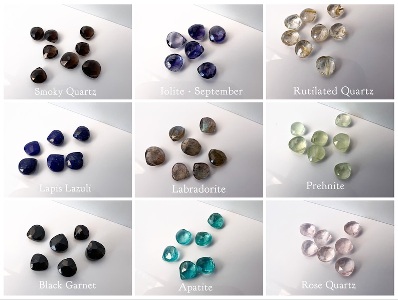 Pu&ograve; includere: Assortimento di nove cabochon di pietre preziose diverse, tra cui quarzo affumicato, iolite, quarzo rutilato, lapislazzuli, labradorite, prehnite, granato nero, apatite e quarzo rosa.