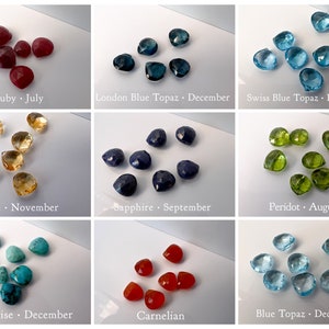 Pu&ograve; includere: Assortimento di pietre preziose sfaccettate a forma di cuore in vari colori, tra cui rubino rosso, topazio blu, peridoto verde, citrino giallo e turchese. Ogni pietra preziosa &egrave; etichettata con il suo nome e il suo mese di nascita.