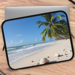 May include: Laptop sleeve featuring a tropical beach scene with a white sandy shore, turquoise water, and palm trees under a bright blue sky. The sleeve has a black border and a zipper closure.