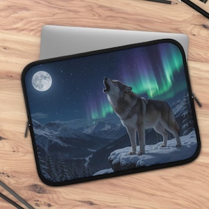 May include: A rectangular laptop sleeve featuring a graphic print of a grey wolf howling on a snowy mountain cliff under a full moon and vibrant green and purple aurora borealis lights against a dark starry night sky with a black zipper border.