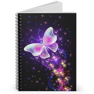 May include: Spiral-bound notebook with a colourful butterfly design. The butterfly has iridescent wings in pink, purple, and blue, set against a black background with sparkling stars. The notebook's cover is a visual celebration of fantasy and nature.