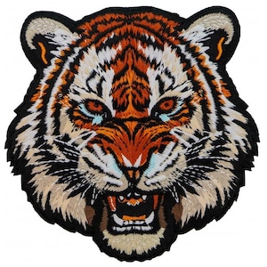 Puede incluir: Parche bordado que representa una cabeza de tigre con la boca abierta y dientes visibles. El diseño utiliza colores naranja, negro, blanco y beige, con costuras detalladas. El parche tiene un borde negro y es adecuado para ropa o accesorios.