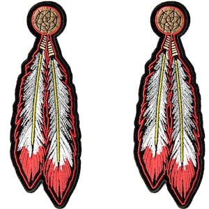 Peut inclure: Deux écussons brodés représentant des plumes amérindiennes. Chaque écusson a une bordure noire, une plume rouge et blanche, une tige centrale jaune et un attrape-rêves marron et doré en haut.