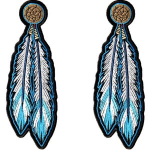 May include: Two embroidered patches featuring a feather design. Each patch has a black border, a circular top with a tan pattern, and a feather with white and turquoise blue details. The patches are likely for clothing or accessories.