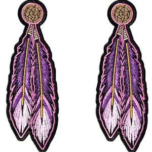 May include: Two embroidered patches featuring a purple feather design with a yellow center and pink accents. Each patch has a dreamcatcher at the top and a black border. The patches are suitable for clothing or accessories.