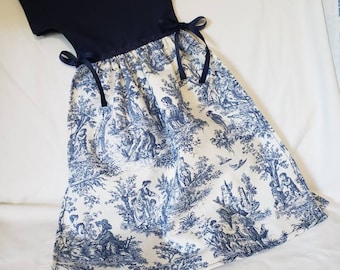 May include: A blue and white dress with a blue bodice and a white skirt with a toile pattern. The dress has short sleeves and a tie at the waist.
