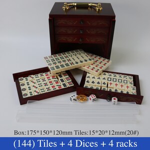 May include: A complete Mahjong set with 144 tiles, 4 dice, and 4 racks. The tiles are cream-colored with red and black markings, stored in a dark wooden box with drawers. The box measures approximately 6.9 x 5.9 x 4.7 inches.