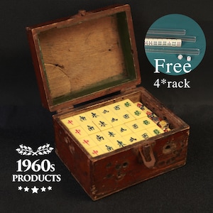 May include: A vintage Mahjong set in a wooden box, with ivory tiles featuring Chinese characters. The box is open, revealing the tiles, dice, and racks. The box is marked with "1960s PRODUCTS" and "Free 4*rack".