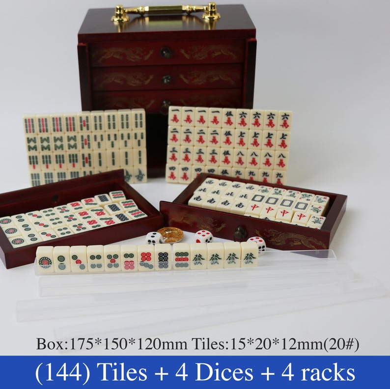 May include: A complete mahjong set with 144 tiles, 4 dice, and 4 racks. The tiles are cream-colored with black, red, and green symbols. The set includes a dark wooden box with drawers and a gold-colored handle. The box measures 6.9 x 5.9 x 4.7 inches.