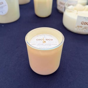 Puede incluir: Varias velas de color &aacute;mbar en frascos de vidrio. La etiqueta de la vela delantera dice "coco loco" y enumera la fragancia como &aacute;mbar, almendra y coco tostado. Cada vela pesa 71 g.