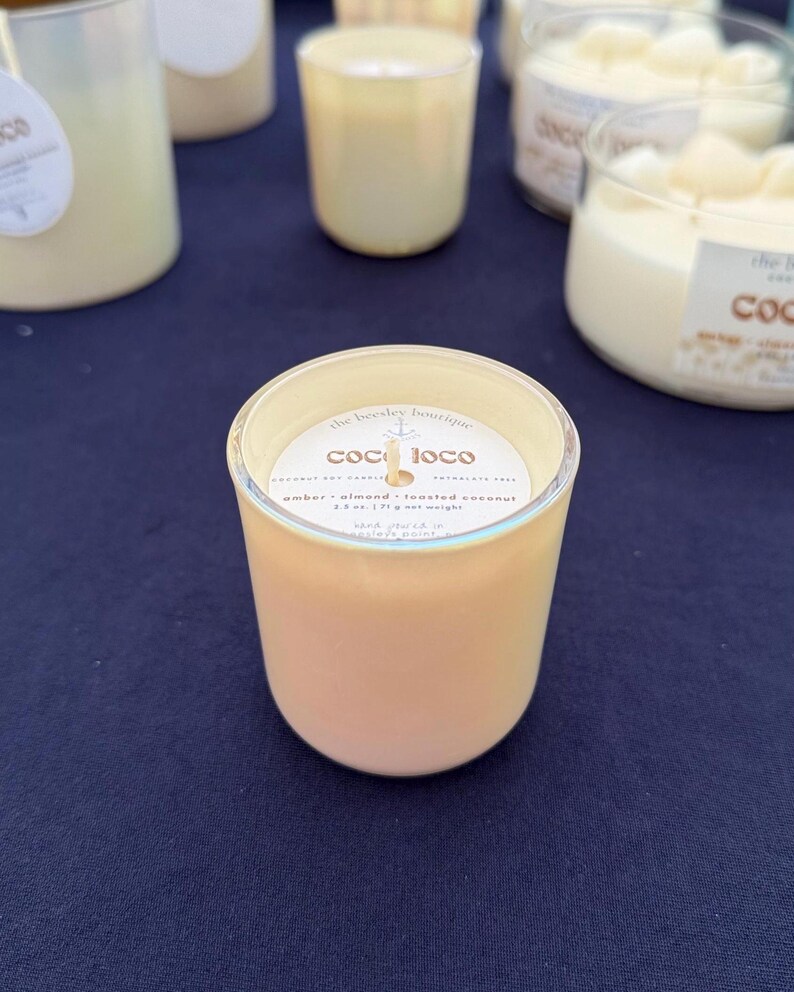 Puede incluir: Varias velas de color &aacute;mbar en frascos de vidrio. La etiqueta de la vela delantera dice "coco loco" y enumera la fragancia como &aacute;mbar, almendra y coco tostado. Cada vela pesa 71 g.