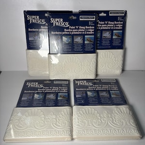 May include: Four packages of Super Fresco Paint 'N' Hang Borders by Graham & Brown. Each package contains a roll of off-white, embossed wallpaper border featuring a repeating fan-like floral pattern, measuring 5 yards or 4.57 meters in length.