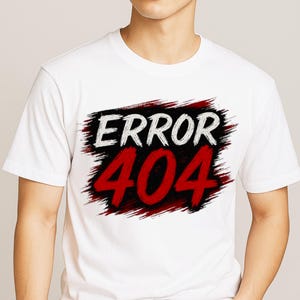May include: White t-shirt with the text "ERROR 404" in white and red, set against a black and red brushstroke design. The shirt is a short-sleeved crew neck.