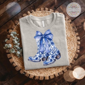 Chinoiserie cow girl boot shirt, blue bow, Blue cow girl boots, Chinoiserie, blue, cute, coquette, Bella + Canvas, T - Shirt