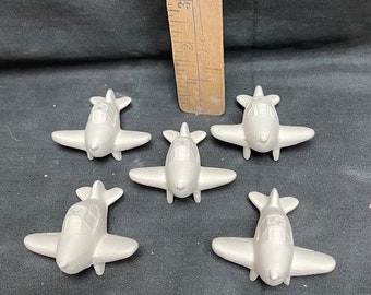 Ornamenti in ceramica grezza Duncan a forma di aereo, pronti per essere dipinti.