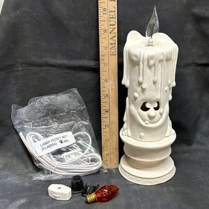 May include: A white ceramic candle lamp post kit with a dripping candle design. The kit includes a white cord, a light bulb, and a socket. The packaging says "LAMP POST KIT (ELK004) 10 qty."