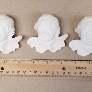 Puede incluir: Tres esculturas de cabeza de querubín blancas de cerámica con alas. Cada escultura mide aproximadamente 7,6 cm de ancho.