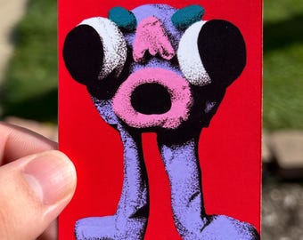 May include: A rectangular sticker featuring a vibrant red background with a central purple creature illustration. The creature has two large black eyes, a pink nose, teal accents, and a prominent pink circular mouth, standing on two purple legs.