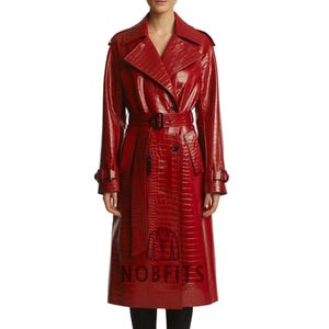 Könnte beinhalten: Ein roter Trenchcoat mit Krokodiltextur. Der Mantel hat ein doppelreihiges Design, einen Gürtel in der Taille und einen klassischen Kragen. Der Mantel ist knielang und hat lange Ärmel.