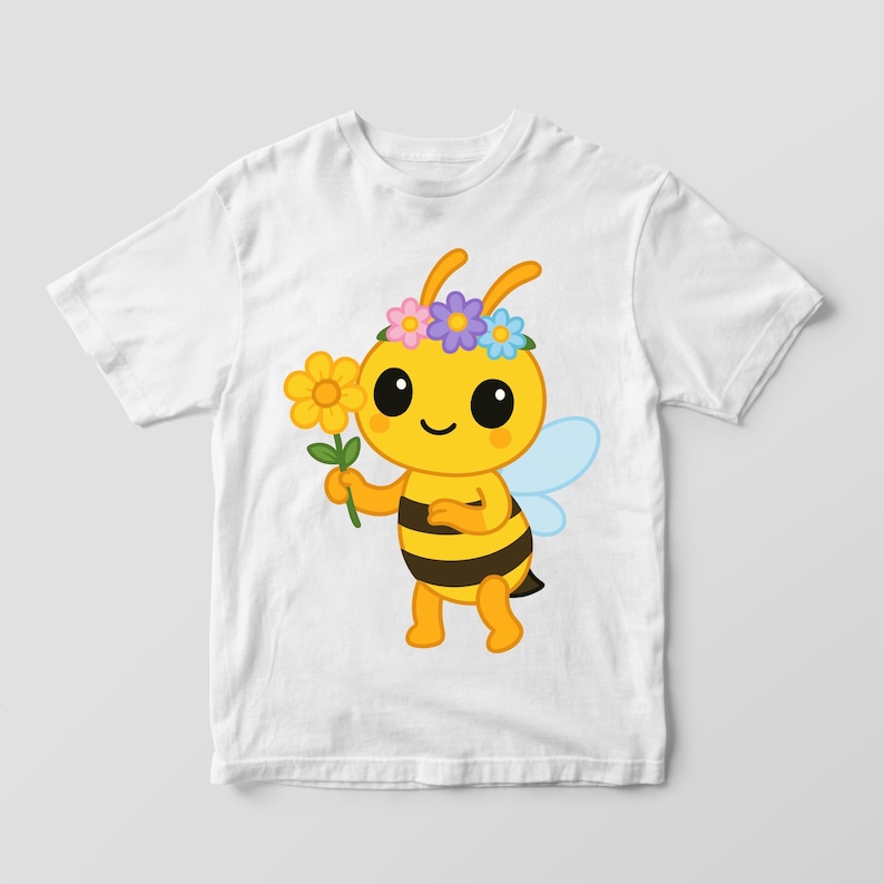 May include: White t-shirt featuring a cartoon bee holding a yellow flower. The bee is yellow with black stripes, blue wings, and a flower crown. The design is centered on the shirt.