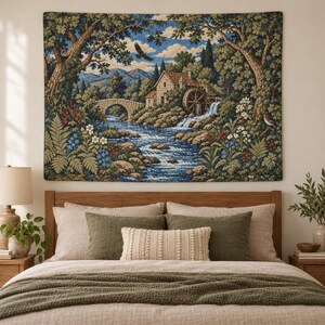 May include: A rectangular woven wall tapestry featuring a landscape scene with a stone water mill, a flowing river, a stone bridge, and a flying bird. The scene is framed by large green trees and colourful wildflowers in shades of blue, red, and white.