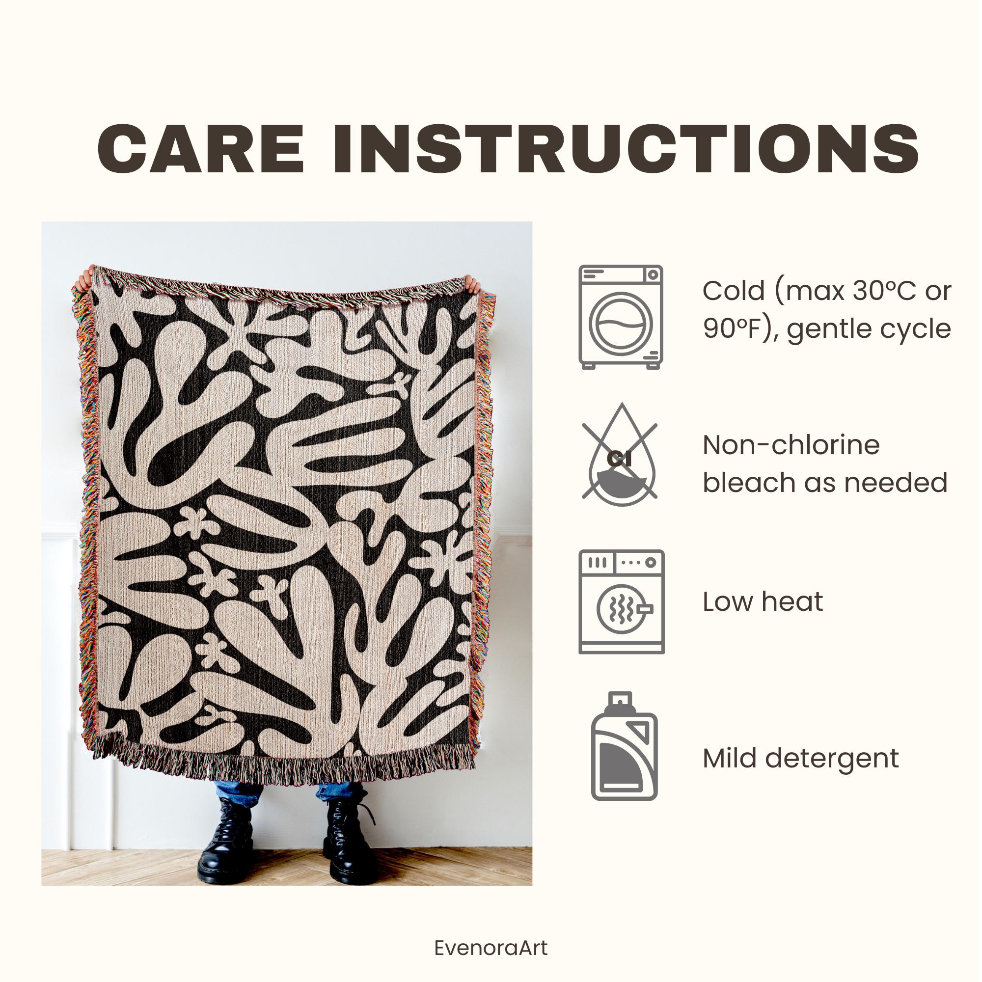 May include: A patterned throw blanket with a black and beige abstract design. The blanket has a fringed edge and the words "CARE INSTRUCTIONS" are at the top. Care instructions include cold wash (max 30&deg;C), non-chlorine bleach, low heat, and mild detergent.