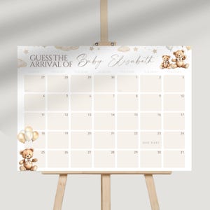 Peut inclure: Un calendrier de baby shower avec le texte "Devinez l'arrivée de Bébé Elizabeth". Le calendrier présente une palette de couleurs neutres avec des illustrations d'ours en peluche et de ballons. Il est affiché sur un chevalet en bois.