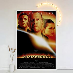 Puede incluir: Un póster enmarcado de la película "Armageddon" con Bruce Willis, Ben Affleck y Liv Tyler. El póster tiene un fondo rojo y naranja con el título de la película y el lema: "Por amor. Por honor. Por la humanidad."