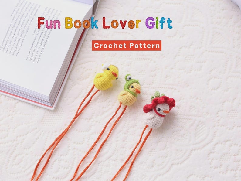 May include: Three handmade crochet bookmarks in the shape of birds, with orange strings. One is yellow, one is yellow with a green hat, and the third is white with a red headpiece. The text "Fun Book Lover Gift" and "Crochet Pattern" are visible.
