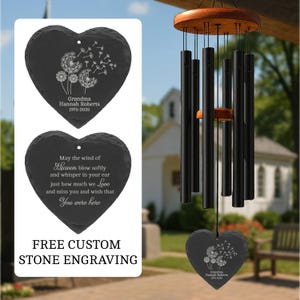 May include: A black wind chime with a wooden top and a heart-shaped slate stone. The stone is engraved with a dandelion design and the text "Grandma Hannah Roberts 1975-2025". Another heart-shaped stone has an engraved poem. The image also includes the text "FREE CUSTOM STONE ENGRAVING".