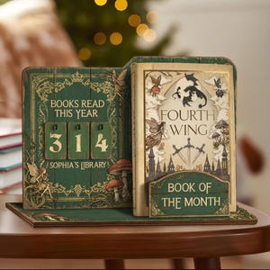 Puede incluir: Un expositor de madera con temática de libros, en verde y dorado. Muestra "314" libros leídos este año, y un libro titulado "Fourth Wing". El expositor también incluye el texto "Book of the Month".