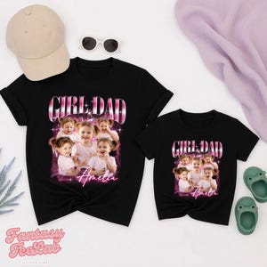 K&ouml;nnte beinhalten: Zwei schwarze T-Shirts mit dem Text "GIRL DAD" in einem rosa-wei&szlig;en Design, mit einem Foto eines jungen M&auml;dchens. Der Name "Amelia" ist unter dem Foto geschrieben. Eine beige Baseballkappe, Sonnenbrille und gr&uuml;ne Sandalen sind ebenfalls im Bild.
