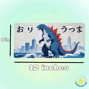 May include: License plate featuring a blue Godzilla-like creature with red dorsal fins, standing in front of a city skyline. The plate is 12 inches wide and 6 inches tall, with Japanese characters at the top.