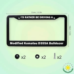 May include: Black license plate frame with the text "I'D RATHER BE DRIVING A Modified Komatsu D355A Bulldozer". The frame measures 31cm wide and 16cm high. Includes mounting hardware. The frame is black.