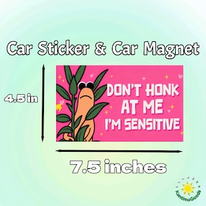 May include: A rectangular car sticker or magnet, 7.5 inches wide and 4.5 inches tall, with a pink background. It features a cartoon character and the text "DON'T HONK AT ME I'M SENSITIVE".