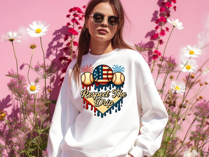 May include: White sweatshirt with a graphic design of baseballs, fireworks, and an American flag. The graphic is in a heart shape with the text "Respect The Drip" below it.
