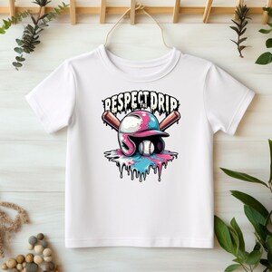 May include: White t-shirt with a graphic of a baseball helmet with dripping paint and two baseball bats. The text "Respect the Drip" is above the graphic.