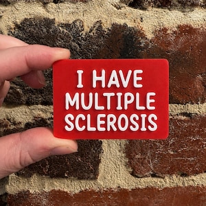 May include: A rectangular red sign with white raised lettering that reads I HAVE MULTIPLE SCLEROSIS. The sign has a smooth, flat surface and features bold, sans-serif text centered on the front, providing a clear and legible message for communication.