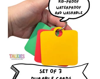 May include: A set of three square communication cards in yellow, red, and green, held together by a metal ring. The cards feature text stating "DURABLE KID-PROOF WATERPROOF AND WASHABLE" and "SET OF 3 DURABLE CARDS" with the brand name TALKIES.
