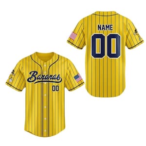 May include: Yellow baseball jersey with black pinstripes. The jersey features the word "Bananas" in navy blue script on the front, along with the number "00". The back of the jersey has the number "00" and the word "NAME". American flag patches are on the sleeves.