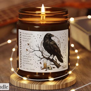 May include: A 9 oz candle in a brown glass jar with a lit wick. The label features a black raven perched on a branch, a full moon, a small candle, and a skull. The text reads SAMHAIN HARVEST, along with decorative script and small stars.
