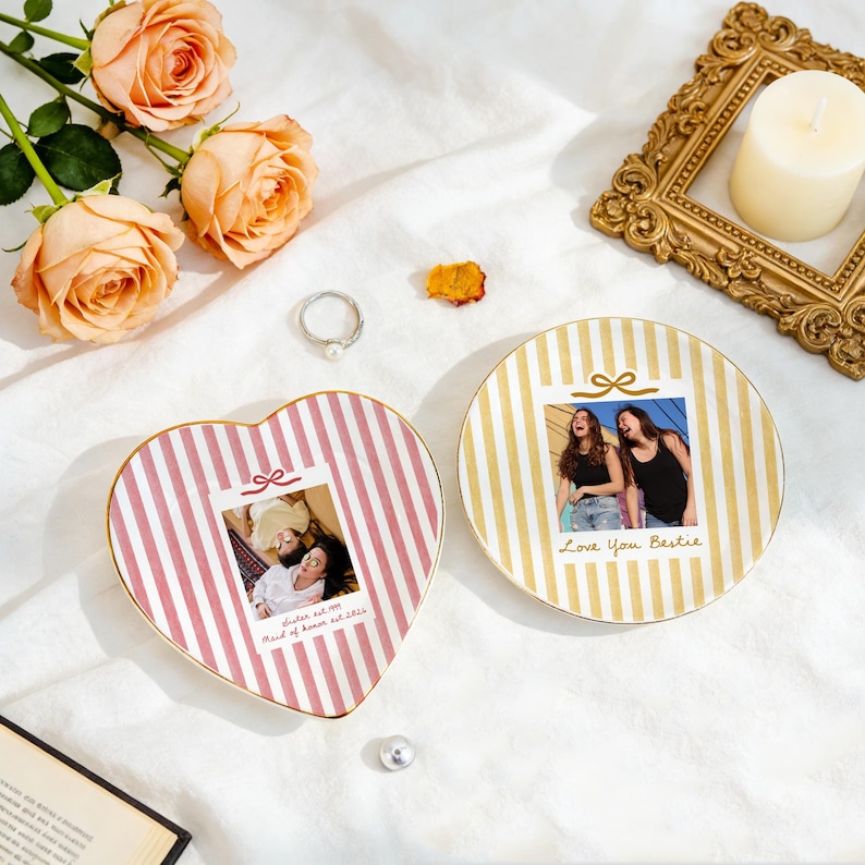 Peut inclure: Un plat en c&eacute;ramique en forme de c&oelig;ur &agrave; rayures roses et un plat rond &agrave; rayures dor&eacute;es, tous deux orn&eacute;s de photos personnalis&eacute;es. Le plat en c&oelig;ur affiche une photo avec le texte "Sister est 1994 Maid of honor est 2024" et le plat rond "Love You Bestie".