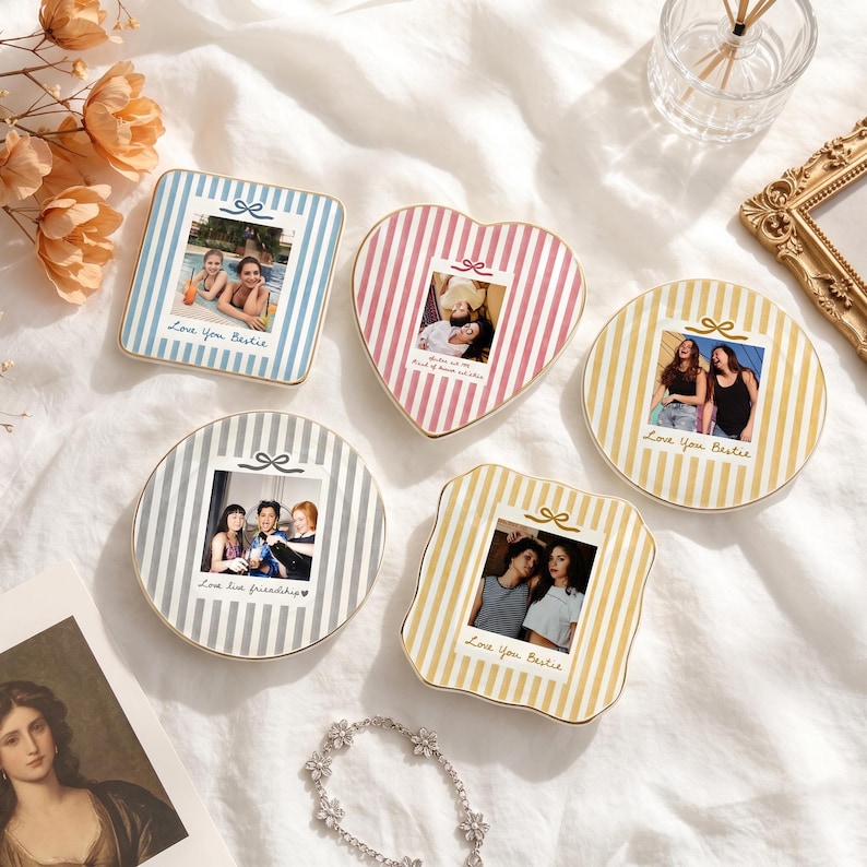Peut inclure: Cinq miroirs de poche d&eacute;coratifs de formes carr&eacute;e, c&oelig;ur, ronde et festonn&eacute;e, avec des rayures verticales bleues, roses, jaunes ou grises. Chaque miroir pr&eacute;sente une photographie centrale et le texte Love You Bestie ou Love live friendship.
